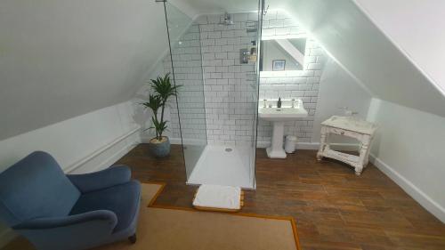 a bathroom with a sink and a blue chair at Tirindrish House B&B in Spean Bridge