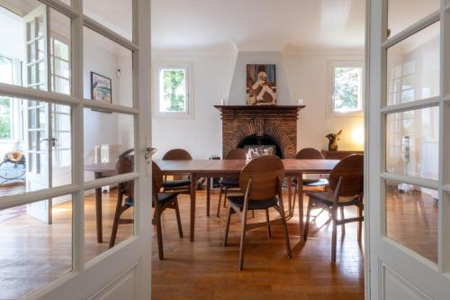 une salle à manger avec une table et une cheminée dans l'établissement Villa Poirier-15 personnes - Piscine chauffée CAUTION OBLIGATOIRE, à Argent-sur-Sauldre