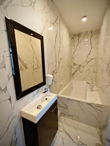 a white bathroom with a sink and a mirror at Marszałkowska Apartments Studio Central Warsaw in Warsaw