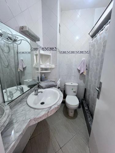 La salle de bains est pourvue d'un lavabo, de toilettes et d'un miroir. dans l'établissement Casablanca Beautiful and Tranquil Family Apartment, à Casablanca
