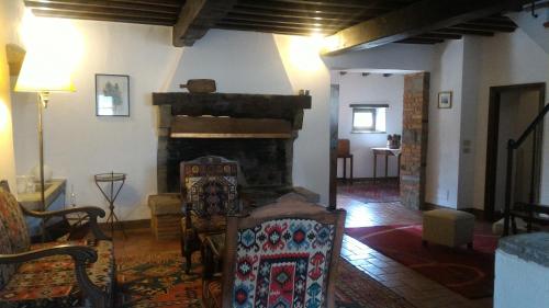 a living room with a fireplace and a chair in it at Villa La Nussa in Capolona
