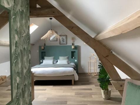 a bedroom with a bed in a attic at La Flânerie in Widehem