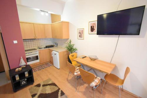 eine Küche mit einem Tisch mit Stühlen und einem TV an der Wand in der Unterkunft Studio in the center 2 in Kavala