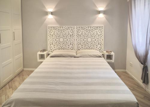 a bedroom with a large bed with a white headboard at Villa Pietrantoni in Tivoli