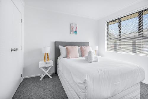 a white bedroom with a white bed and a window at Park view, Proximity, Value in Hamilton