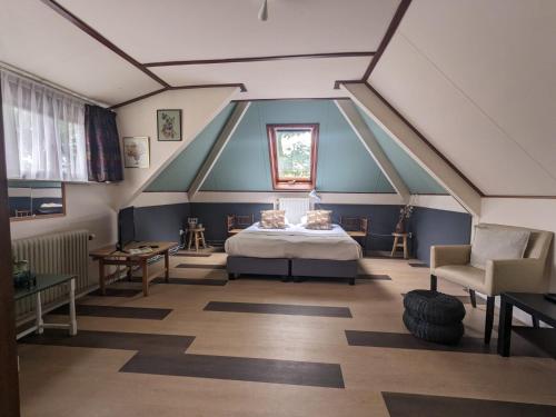 una camera mansardata con letto e finestra di Hotel De Gravin van Vorden a Vorden