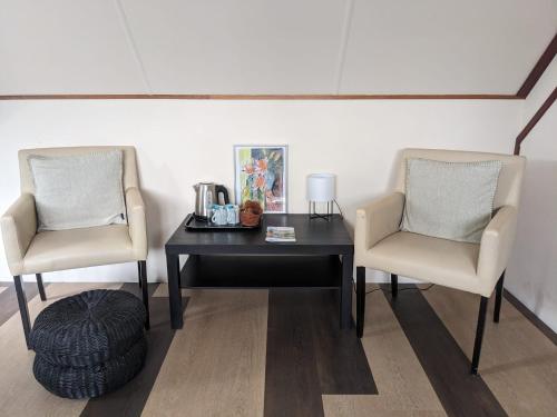 two chairs and a table in a room at Hotel De Gravin van Vorden in Vorden