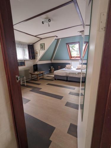 an attic room with a bed and a window at Hotel De Gravin van Vorden in Vorden