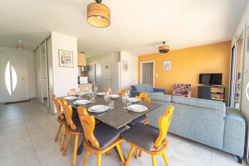 une salle à manger avec une table, des chaises et un canapé dans l'établissement Maison Familiale avec jardin proche de la mer Parking, à Les Sables-dʼOlonne
