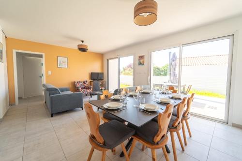 une salle à manger avec une table et des chaises dans l'établissement Maison Familiale avec jardin proche de la mer Parking, à Les Sables-dʼOlonne