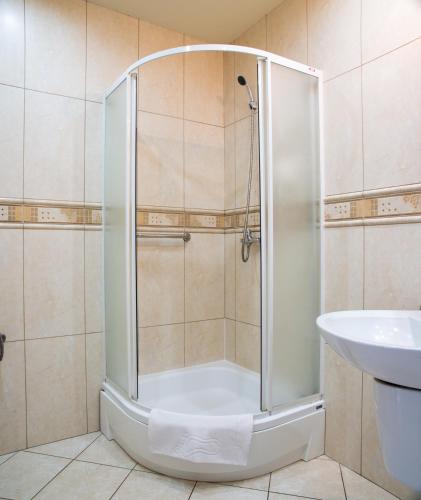 a shower with a glass door in a bathroom at Perła in Leszno