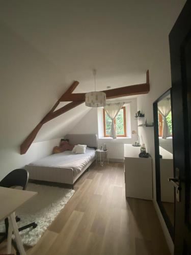 une chambre blanche avec un lit et une fenêtre dans l'établissement Maison proche du circuit des 24 heures., à Teloché