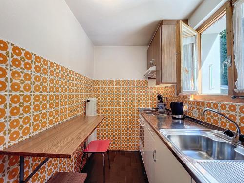 a kitchen with orange tiles on the wall and a sink at pâquerette rez in Verbier
