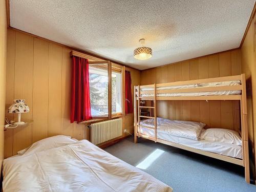 a bedroom with two bunk beds and a window at pâquerette rez in Verbier