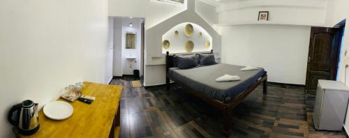 a room with a bed and a table in it at The French Villa Elite in Puducherry