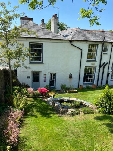 an old white house with a garden at Stratton Gardens in Bude