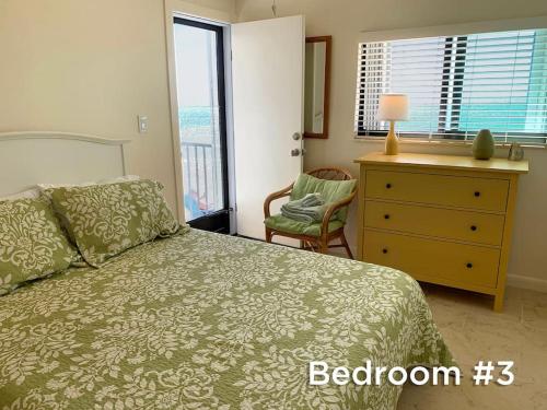 a bedroom with a bed and a dresser with a window at Outstanding Oceanfront Oasis Directly on Beach #8 in Marathon
