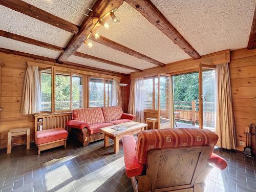a living room with a couch and a table and windows at Pâquerette 1er in Verbier