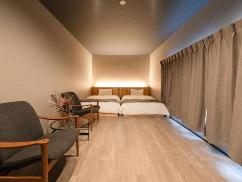 Habitación con 2 camas, sillas y ventana en IZUMO DOGS - Vacation STAY 14434v en Izumo