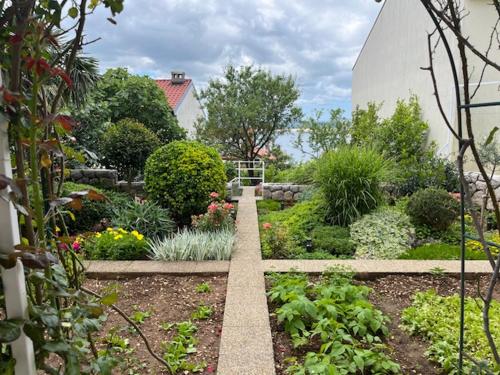 a garden with flowers and plants in a building at Apartman Laura in Dramalj