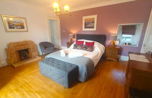una camera da letto con un grande letto e un camino di Tirindrish House B&B a Spean Bridge