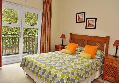 a bedroom with a bed with orange pillows and a window at Olive Green Villa in Negombo for Airport Transit in Katunayaka