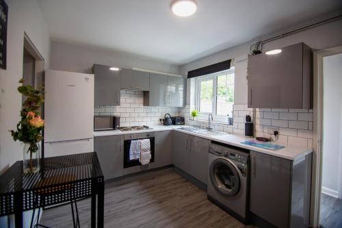 a kitchen with a washer and a washing machine in it at Eastfield House - Southampton in Southampton