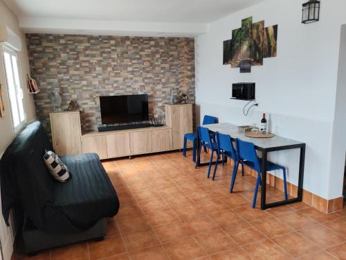 ein Wohnzimmer mit einem Tisch, Stühlen und einem TV in der Unterkunft MIRADOR SAN ROQUE in Las Palmas de Gran Canaria