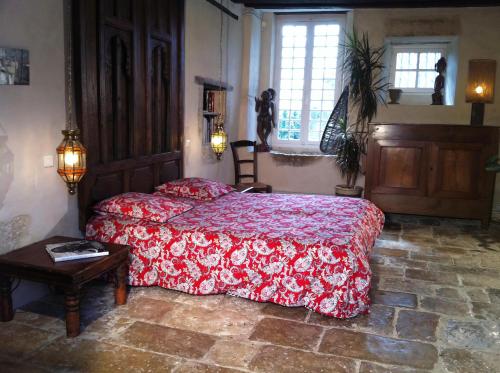une chambre avec un lit avec une couette rouge dans l'établissement Manoir du 17e siècle, parc, piscine chauffée et tennis privé, à Coulounieix-Chamiers