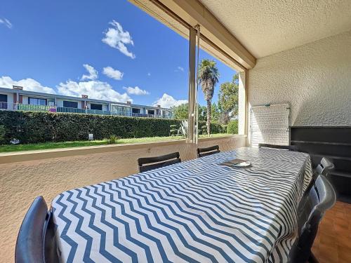 Cette chambre dispose d'une grande fenêtre et d'une table avec des chaises. dans l'établissement Bord de mer 4-6 couchages, à Argelès-sur-Mer