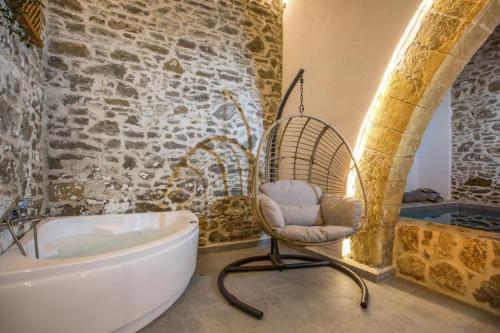a bathroom with a chair next to a bath tub at Villa Gemma 2 next to Faliraki in Kalithies