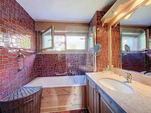 a bathroom with a tub and a sink at Lichen 8 in Verbier