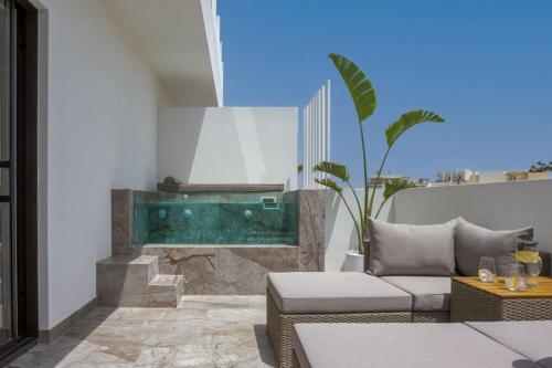 a living room with a swimming pool and a couch at Ethereal White Resort Hotel & Spa in Heraklio