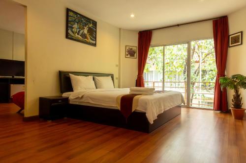 1 dormitorio con 1 cama y puerta corredera de cristal en Kiatthada Resort, en Bangkok