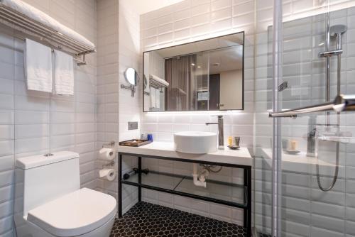 uma casa de banho com um WC, um lavatório e um espelho. em City Suites - Beimen em Taipei