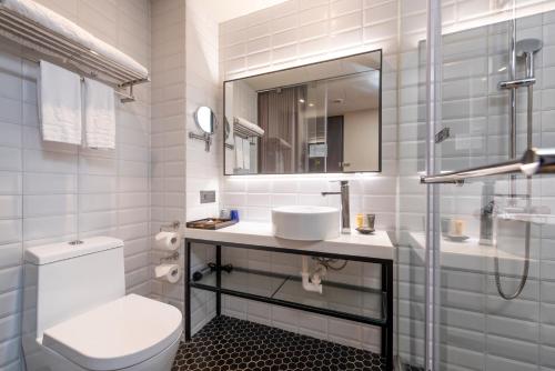 a bathroom with a toilet and a sink and a mirror at City Suites - Beimen in Taipei