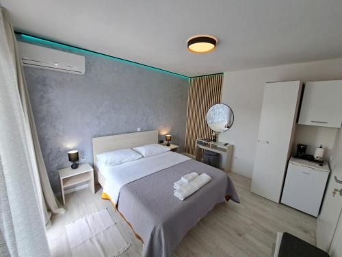 1 dormitorio con 1 cama con 2 toallas en Paulina Harmony Rooms, en Seget Vranjica