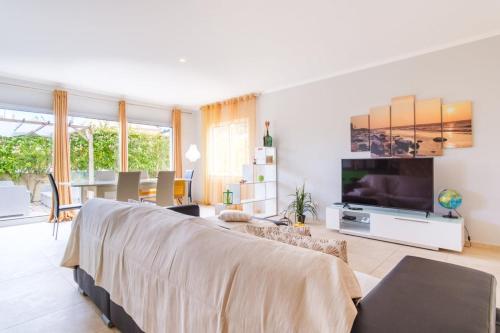 a living room with a couch and a tv at Villa dos Anjos in Porto Santo