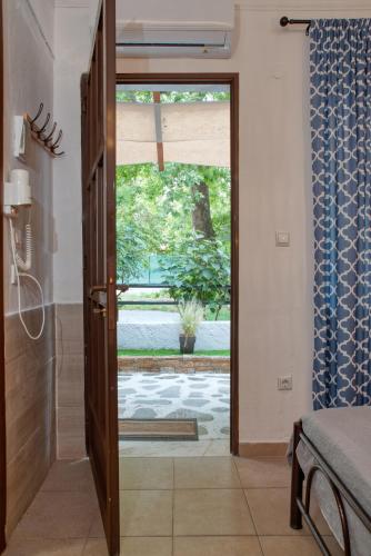a bathroom with a door open to a patio at Ostria Hotel in Skala Potamias
