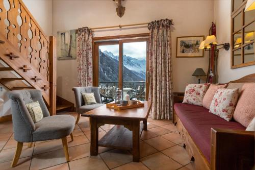 a living room with a couch and a table at Résidence Le Cristal-Mont Blanc 18 - Happy Rentals in Argentiere