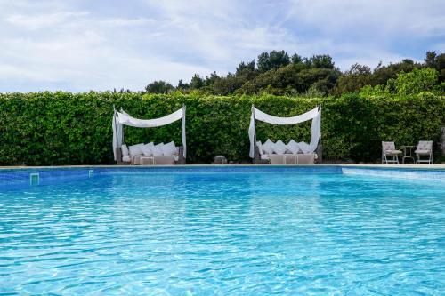 a swimming pool with two chairs at Villa Pesce in Selva di Fasano