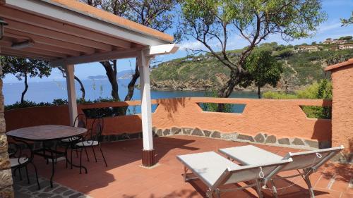 a patio with a table and chairs and a view of the ocean at Appartamenti Pagni in Casa Morcone