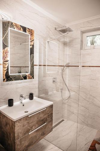 a white bathroom with a sink and a shower at Luxury Wellness Home II. Balatonboglár in Balatonboglár