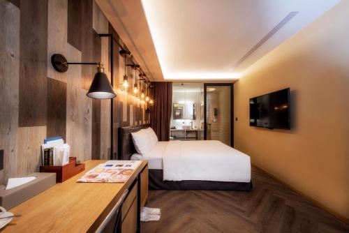 a hotel room with a bed and a kitchen at City Suites - Beimen in Taipei