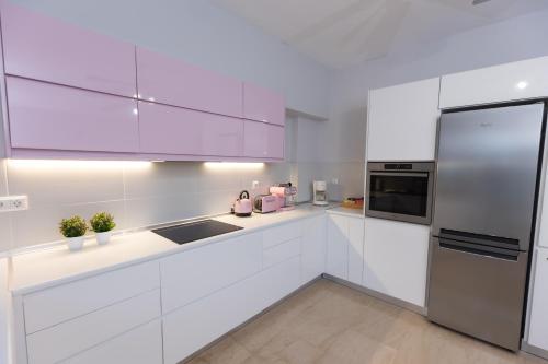 a white kitchen with white cabinets and stainless steel appliances at Silver Palm House Ixia, Rhodes in Ixia