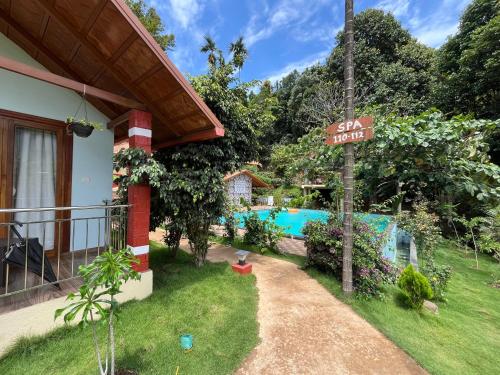 a street sign in front of a house with a pool at Hill Crest Resort - Coorg in Madikeri