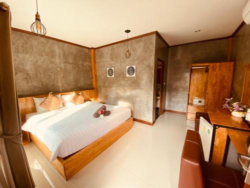 a bedroom with a large bed and a desk at Paradise Land Resort in North Pattaya