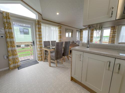 a kitchen and dining room with a table and chairs at Serena Holiday Caravan in Bassenthwaite