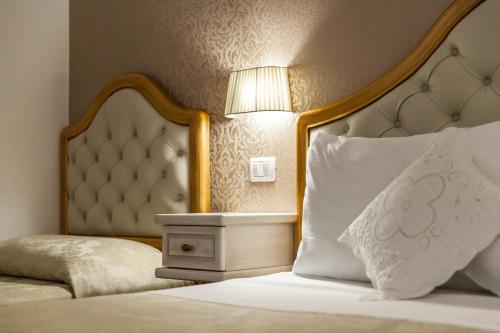 a bedroom with a bed with a headboard and a lamp at Agriturismo Salinola in Ostuni