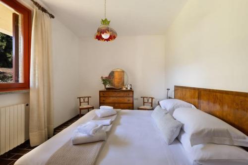 a bedroom with a large bed with white pillows at Villa Lago Maggiore in Lesa